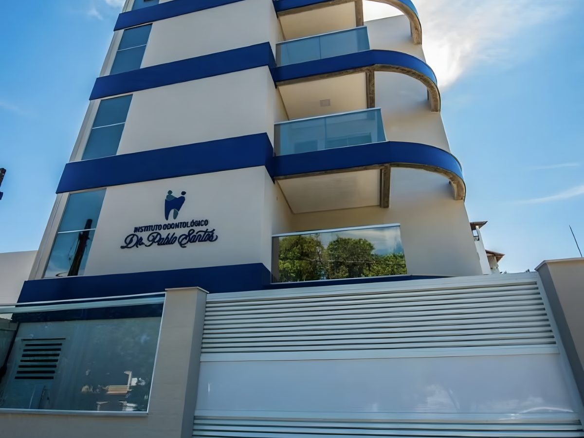 Prédio do Instituto Odontológico Dr. Pablo Santos, branco com faixas azuis, visto da rua