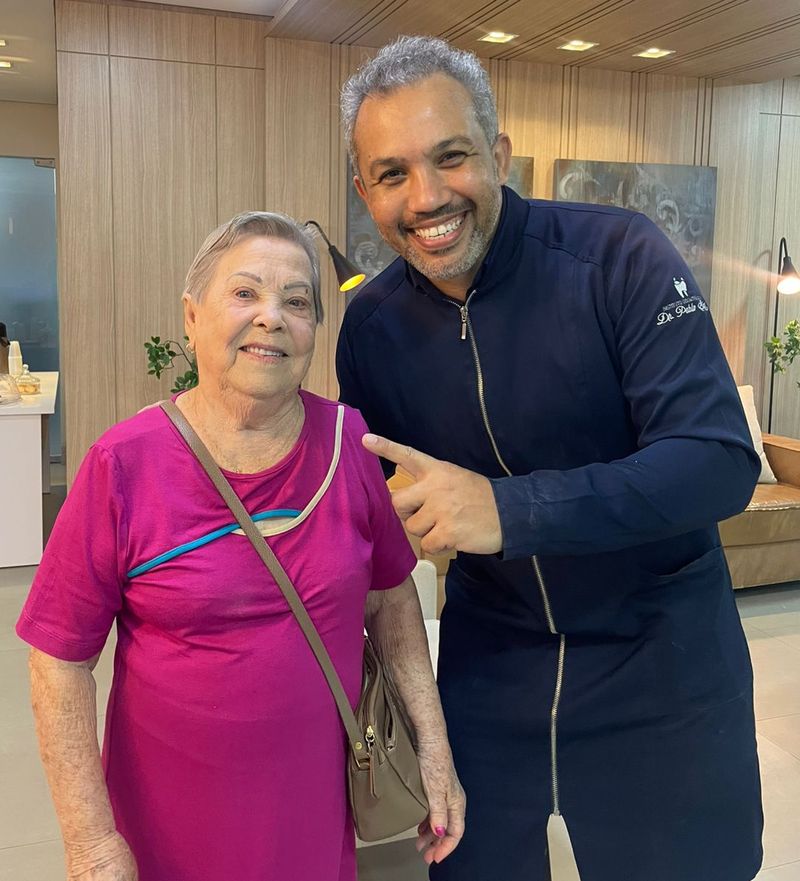 Dona Dalcina, de vestido rosa, ao lado do Dr. Pablo Santos na recepção da clínica